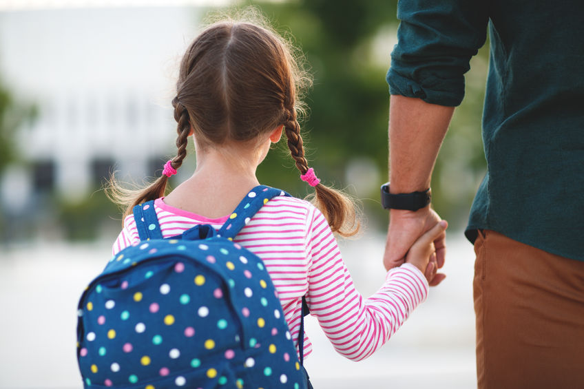 dad w girl backpack first day at school. father leads a little child school girl in first grade